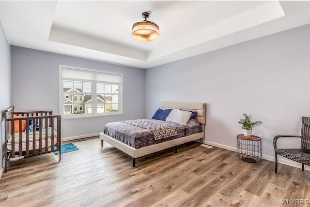 12 Kevwood Ln, Lancaster, NY 14086 - bedroom with baseboards, wood finished floors, and a tray ceiling
