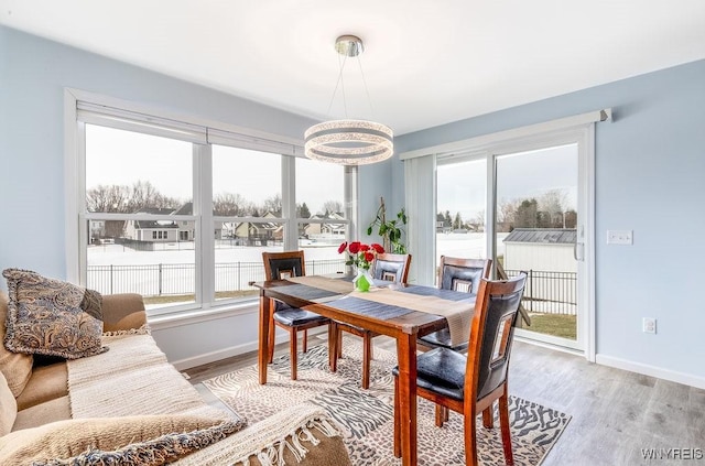 12 Kevwood Ln, Lancaster, NY 14086 - dining area featuring baseboards, light wood-style floors, and a notable chandelier