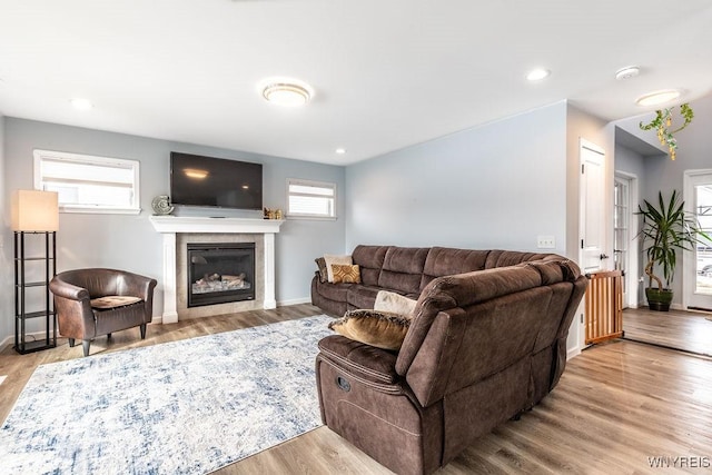 12 Kevwood Ln, Lancaster, NY 14086 - living room featuring recessed lighting, baseboards, a glass covered fireplace, and wood finished floors
