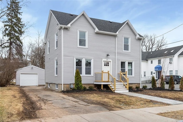 view of front of property with a garage, driveway, roof with shingles, and an outbuilding