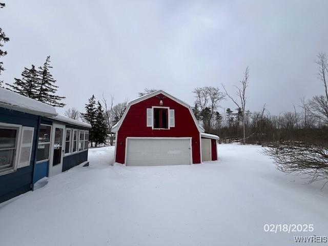 snow covered garage featuring a garage