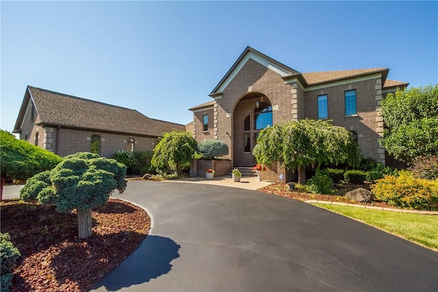 view of front facade featuring brick siding and driveway