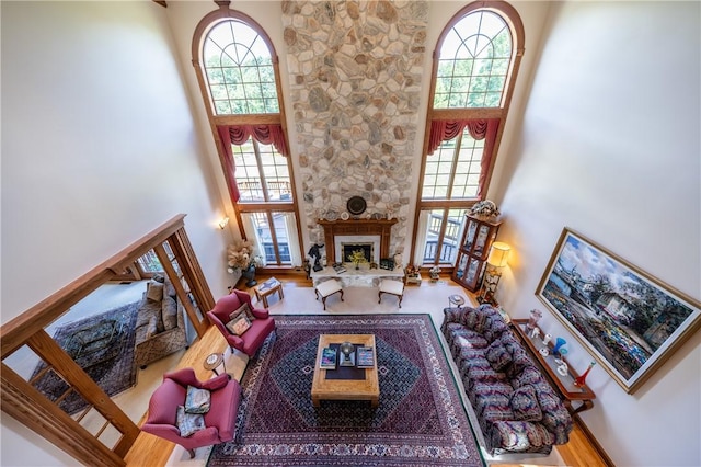 living room with a high ceiling, a fireplace, and wood finished floors