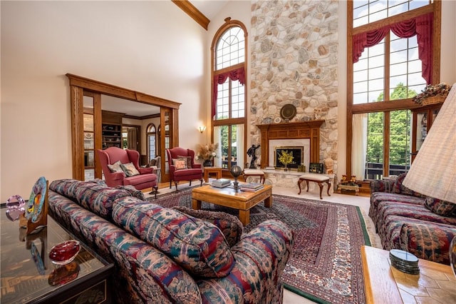 living area with ornamental molding, a fireplace, plenty of natural light, and a high ceiling