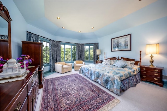 bedroom with a tray ceiling, light colored carpet, and recessed lighting