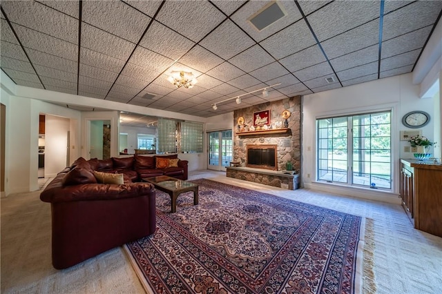 living area with plenty of natural light, carpet flooring, and a stone fireplace