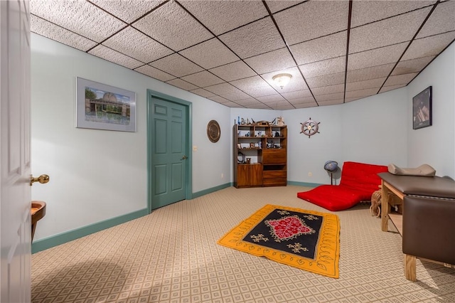 interior space with baseboards and a drop ceiling