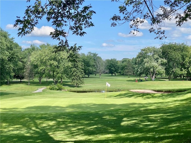 view of community featuring view of golf course and a lawn