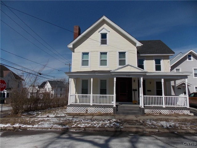 view of front of home featuring covered porch and a chimney