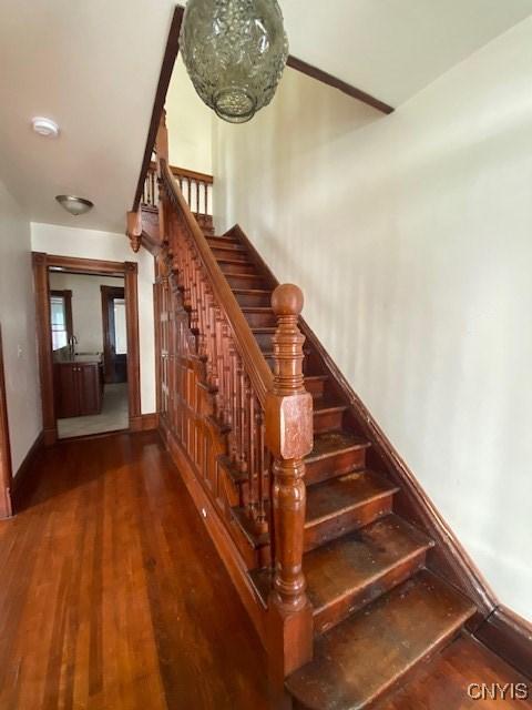 stairs featuring wood finished floors and baseboards