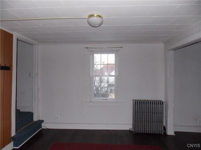 interior space with baseboards, stairway, wood finished floors, and radiator