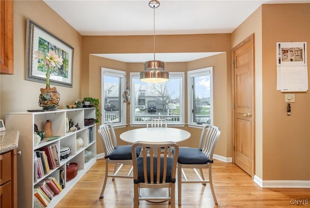 dining room featuring light wood-style flooring and baseboards