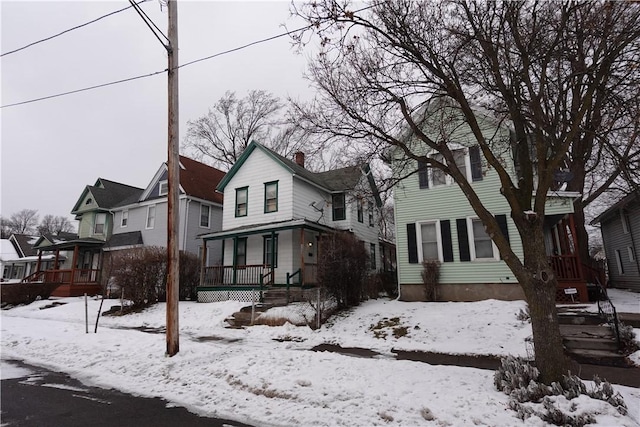 view of front facade with a residential view, a chimney, and a porch