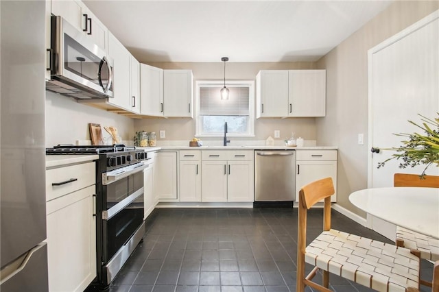 kitchen featuring appliances with stainless steel finishes, white cabinets, a sink, and light countertops