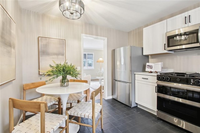 kitchen featuring white cabinets, a chandelier, stainless steel appliances, and light countertops