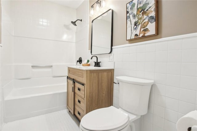 bathroom with tile patterned flooring, toilet, a wainscoted wall, tile walls, and shower / bathing tub combination