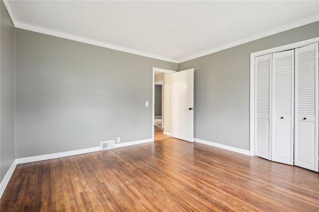 unfurnished bedroom with a closet, baseboards, and wood finished floors