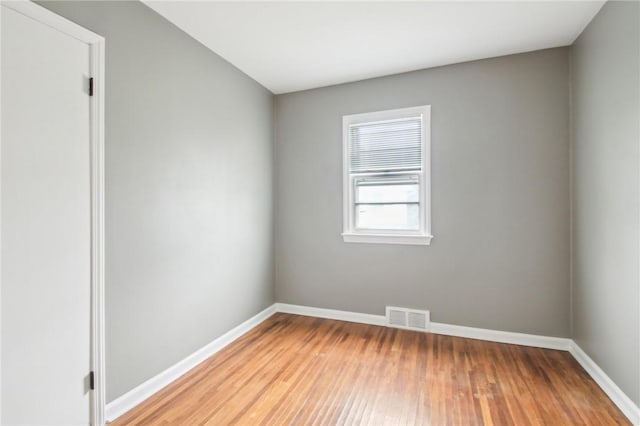 spare room with light wood-style floors, baseboards, and visible vents