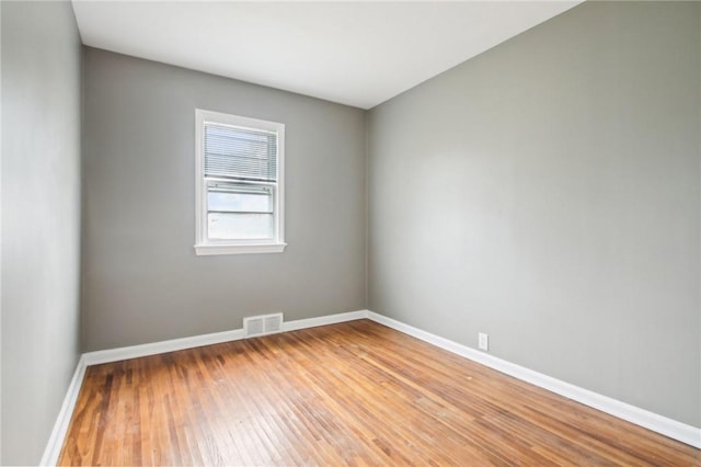 unfurnished room with baseboards, visible vents, and light wood-style floors