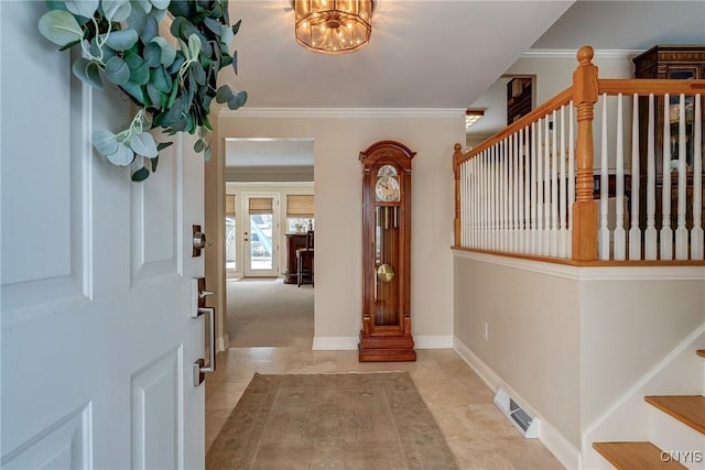 foyer entrance featuring baseboards, visible vents, stairway, crown molding, and a notable chandelier