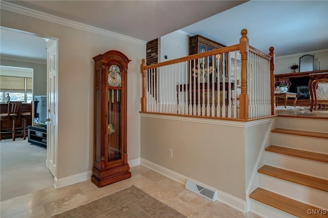 stairs with baseboards, visible vents, and ornamental molding