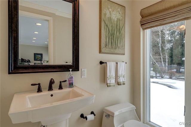 half bathroom with a wealth of natural light, a sink, toilet, and recessed lighting