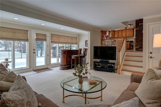 carpeted living area with stairs, crown molding, and a healthy amount of sunlight