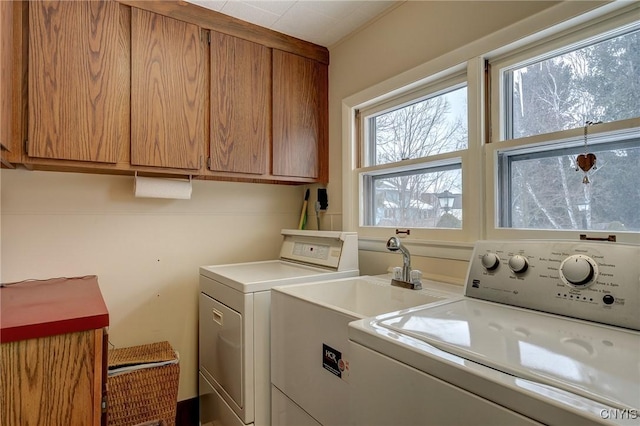 laundry room featuring washer and dryer, cabinet space, and a sink