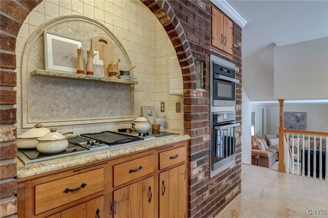 kitchen featuring light stone counters, a fireplace, tasteful backsplash, stainless steel appliances, and brown cabinetry