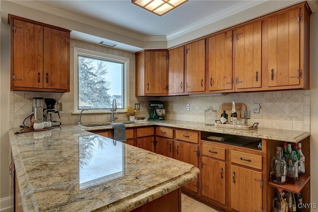 kitchen with brown cabinetry, backsplash, crown molding, and a peninsula