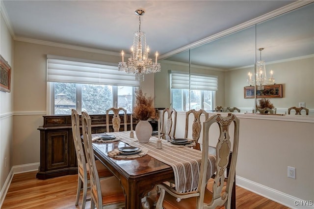 dining room with light wood-type flooring, a healthy amount of sunlight, and a notable chandelier