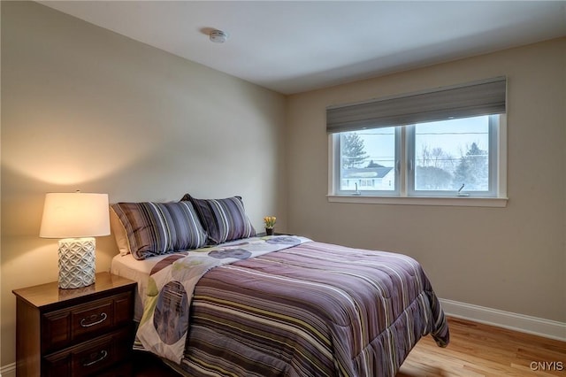 bedroom with baseboards and wood finished floors