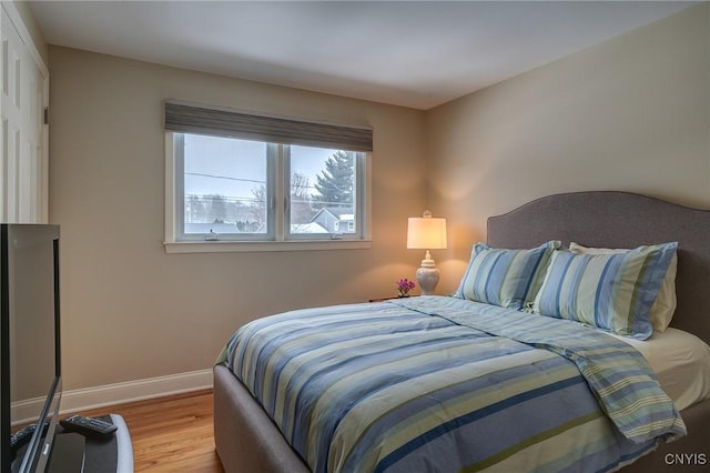 bedroom with baseboards and wood finished floors