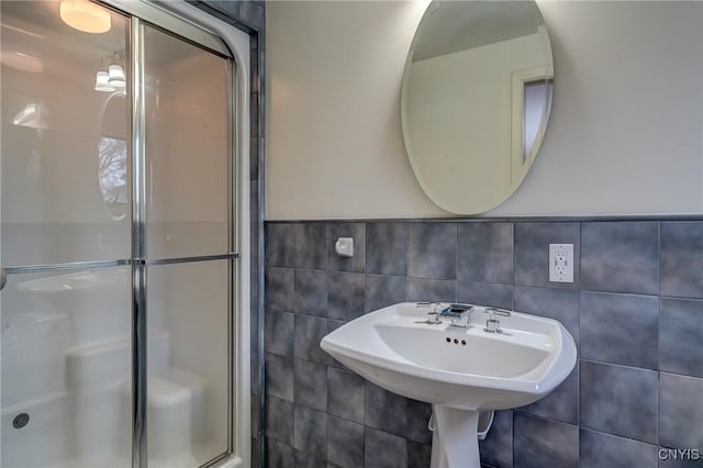 bathroom with a stall shower and tile walls