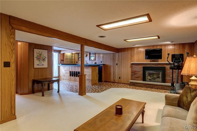 living room featuring carpet floors, a brick fireplace, wooden walls, and beamed ceiling