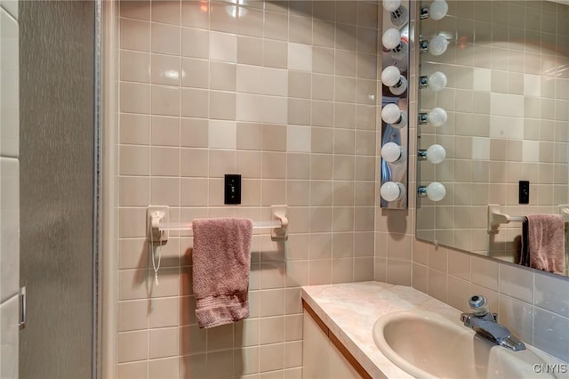 bathroom featuring tasteful backsplash, vanity, and tile walls