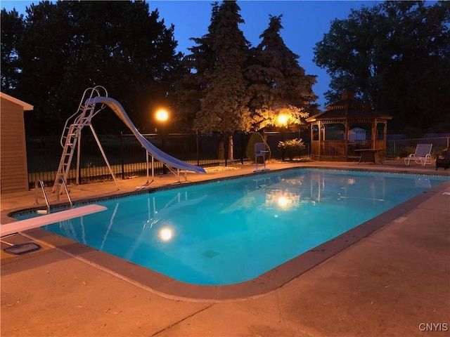 view of pool with a fenced in pool, a gazebo, fence, a water slide, and a diving board