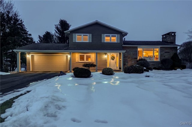 view of front of house with a garage, stone siding, a chimney, and aphalt driveway