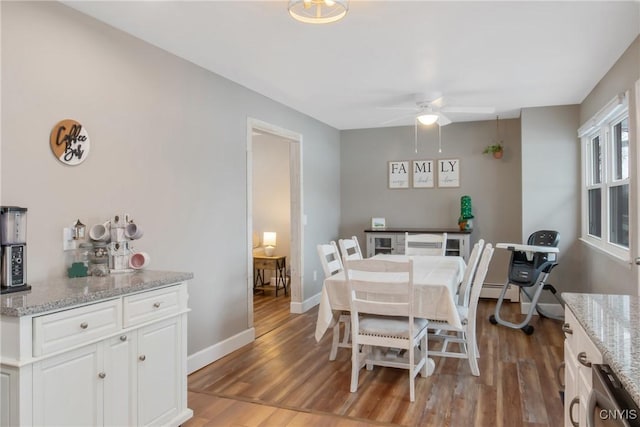 dining area featuring a ceiling fan, baseboards, and wood finished floors