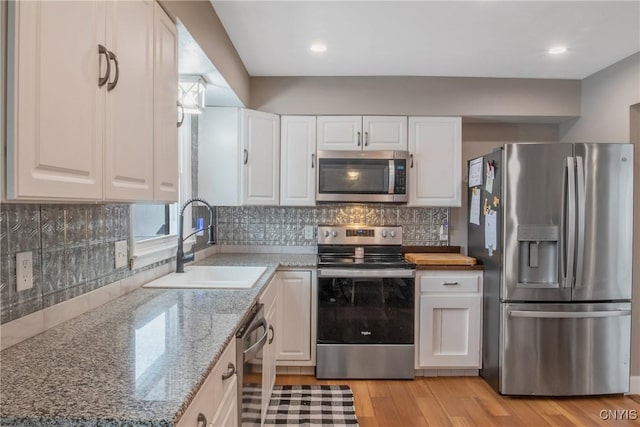 kitchen featuring white cabinetry, stainless steel appliances, and a sink