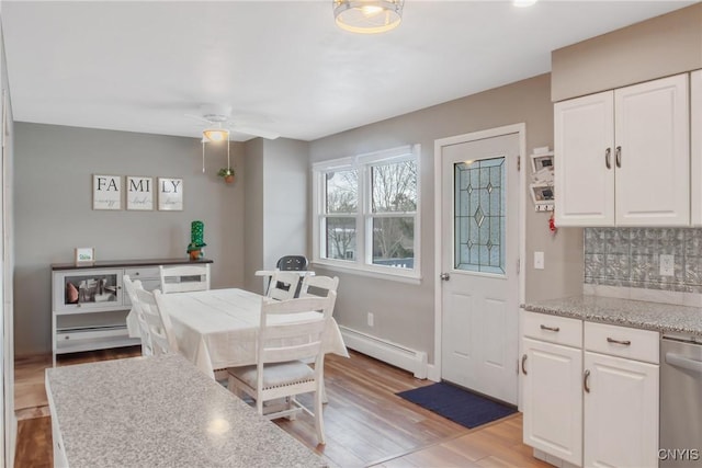 dining area with light wood-style floors, baseboards, a baseboard heating unit, and ceiling fan