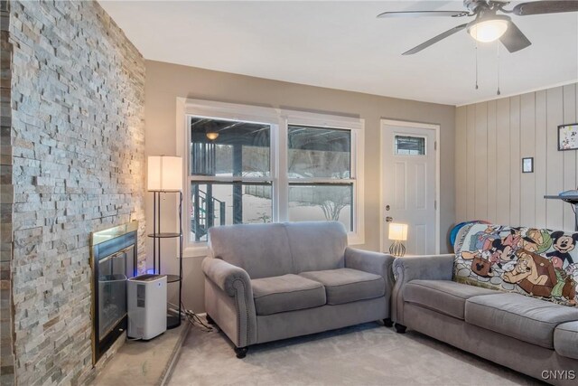 living room featuring a fireplace and ceiling fan