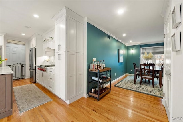 dining room featuring ornamental molding, recessed lighting, visible vents, and light wood-style flooring