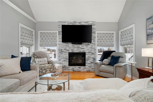 living room featuring vaulted ceiling, a large fireplace, wood finished floors, and baseboards