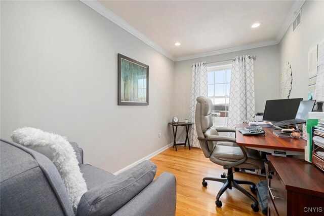 office area featuring baseboards, light wood-type flooring, visible vents, and crown molding