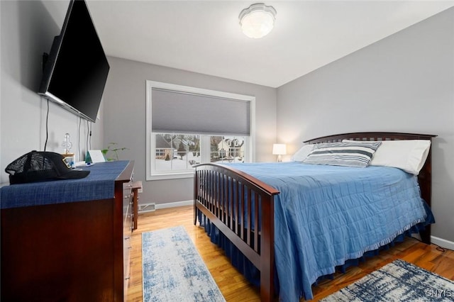 bedroom with baseboards and wood finished floors