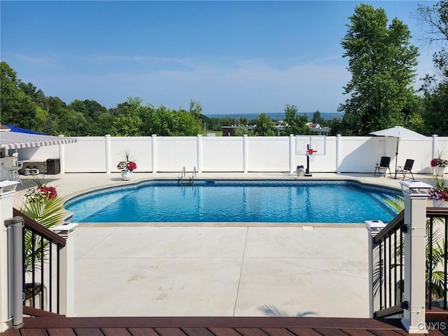 view of swimming pool featuring fence, a fenced in pool, and a patio