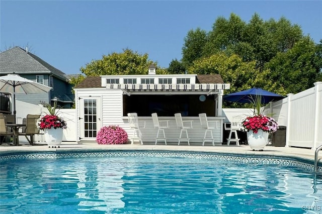 pool with a patio area and fence