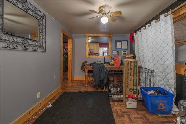 office space featuring a ceiling fan and baseboards