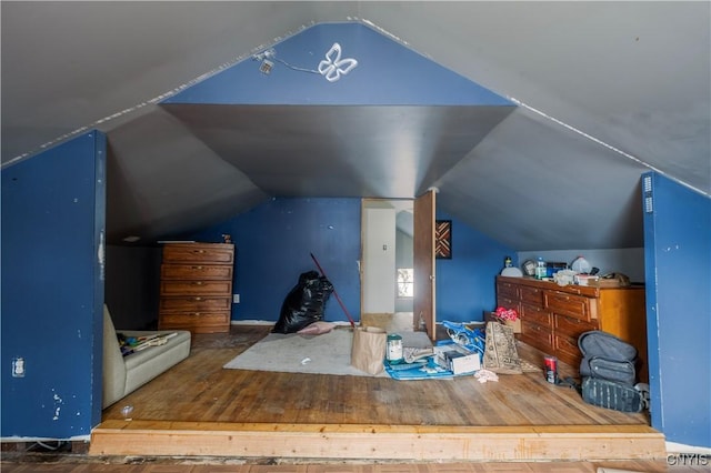 additional living space featuring vaulted ceiling and wood finished floors